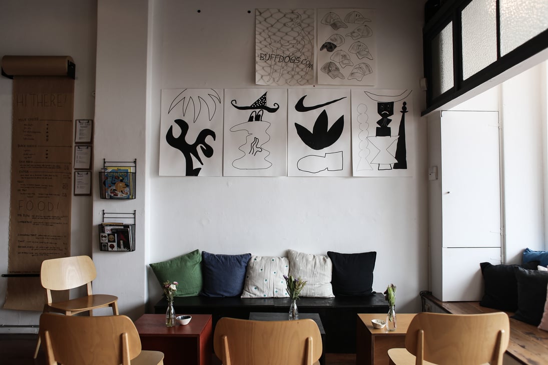 Cafe Tables and Paper Drawings on a Wall